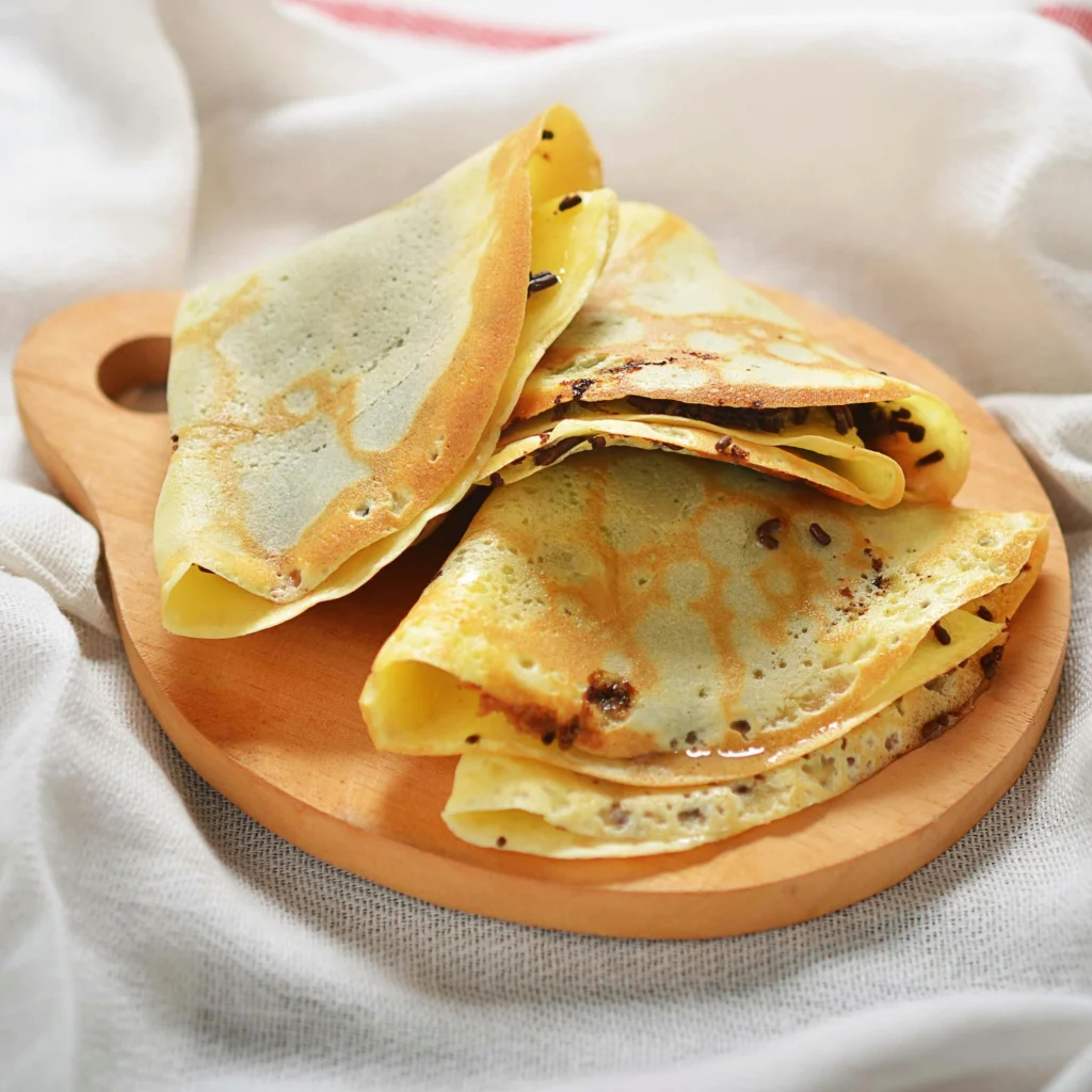 Close-up of homemade chocolate crepes on a cutting board, perfect for a dessert lovers.